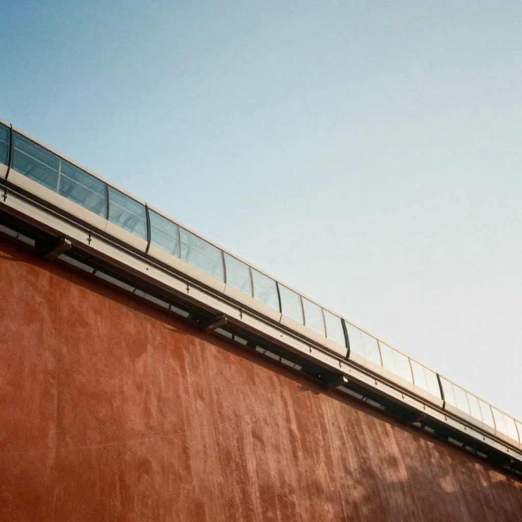 a glass monorail in crisp winter sunlight, soft-grain analog film photography, calm negative space, terracotta and pale 